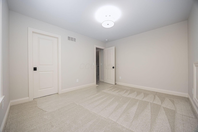 spare room featuring light carpet