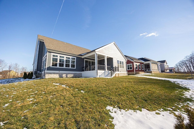 back of house featuring a sunroom and a lawn