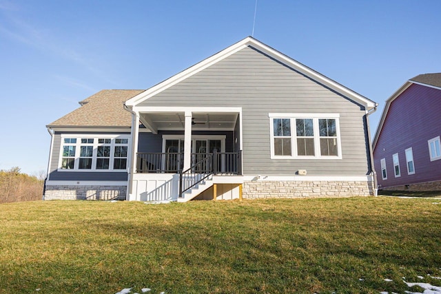 back of property featuring ceiling fan and a lawn