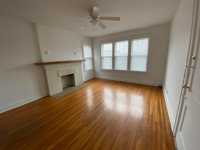 unfurnished living room featuring wood-type flooring, ceiling fan, and a fireplace