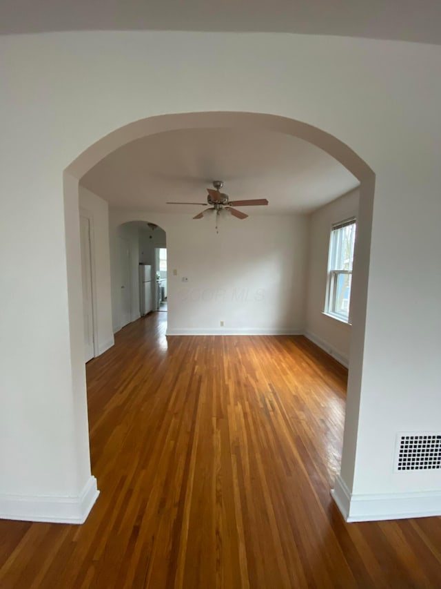 unfurnished living room with dark hardwood / wood-style floors and ceiling fan