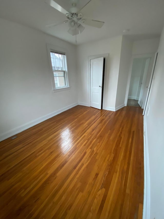 empty room with ceiling fan and hardwood / wood-style floors