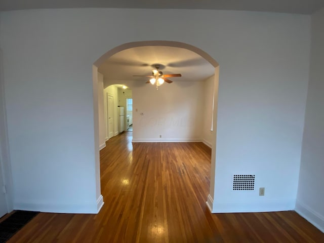 spare room with dark hardwood / wood-style floors and ceiling fan