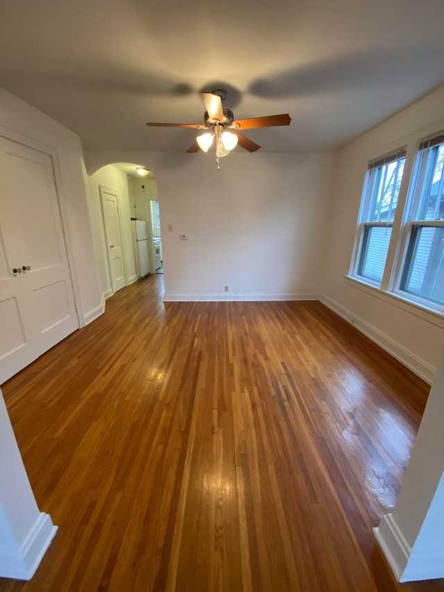 unfurnished living room featuring wood-type flooring and ceiling fan