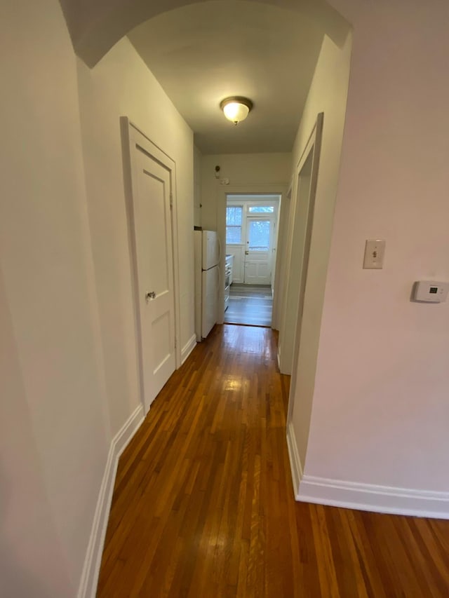 hallway with dark hardwood / wood-style flooring