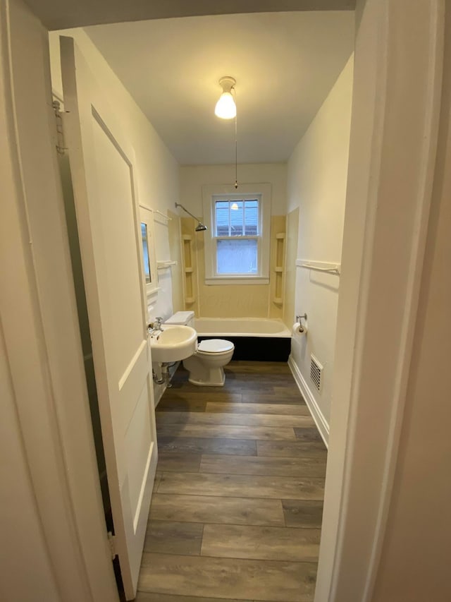 full bathroom with hardwood / wood-style flooring, toilet, sink, and shower / bathing tub combination