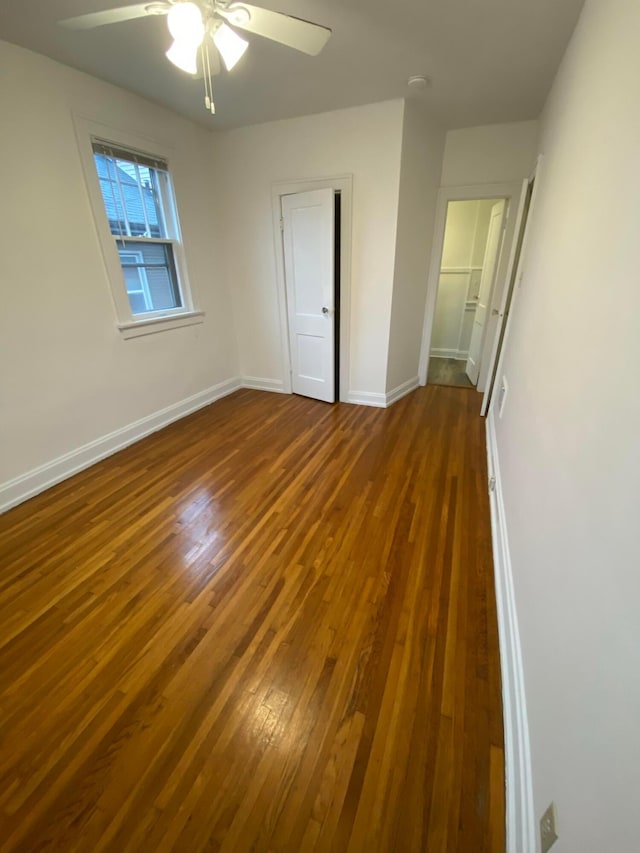 unfurnished bedroom featuring dark wood-type flooring and ceiling fan