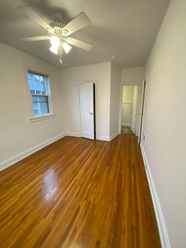 unfurnished bedroom featuring dark wood-type flooring and ceiling fan