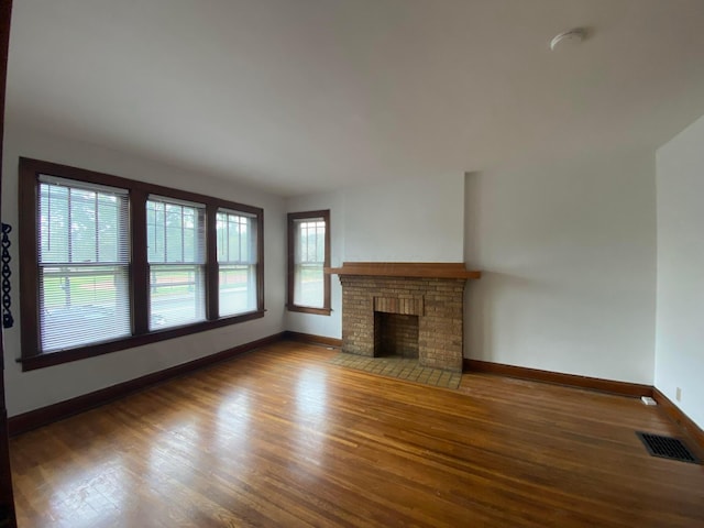 unfurnished living room with hardwood / wood-style flooring and a fireplace