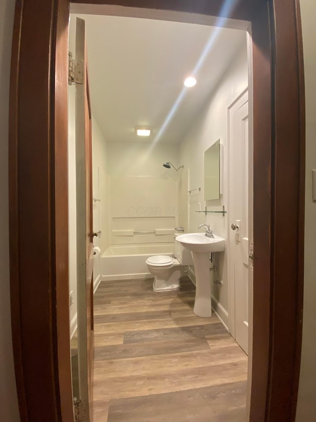 full bathroom with hardwood / wood-style flooring, toilet, shower / bath combination, and sink