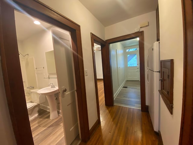 hall with sink and dark wood-type flooring