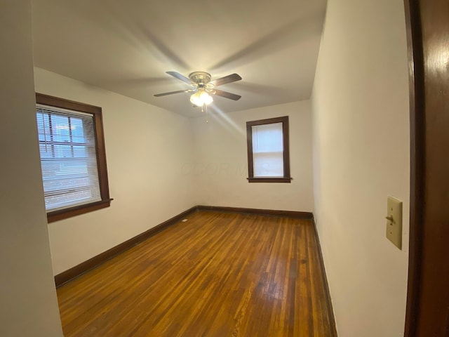 unfurnished room with dark wood-type flooring and ceiling fan