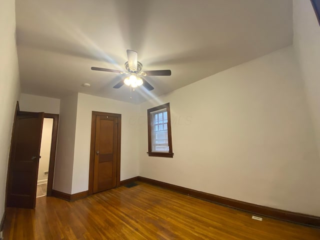 unfurnished bedroom with dark hardwood / wood-style flooring and ceiling fan