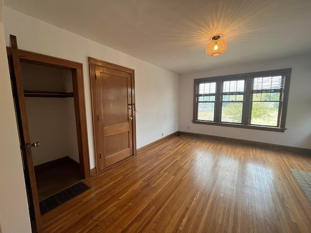 unfurnished bedroom with hardwood / wood-style flooring and a closet