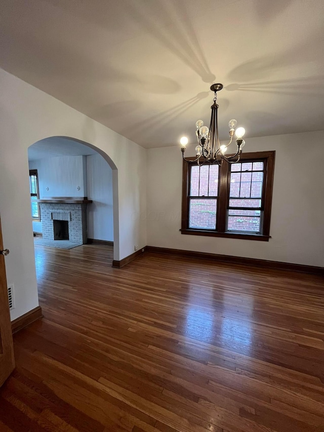 interior space with dark hardwood / wood-style floors, an inviting chandelier, and a fireplace