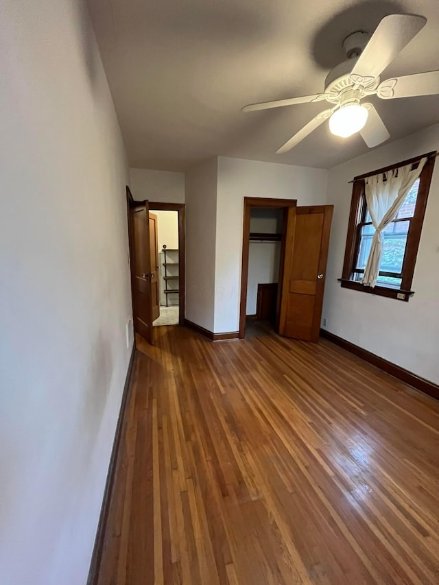 unfurnished bedroom featuring ceiling fan, dark hardwood / wood-style flooring, and a closet