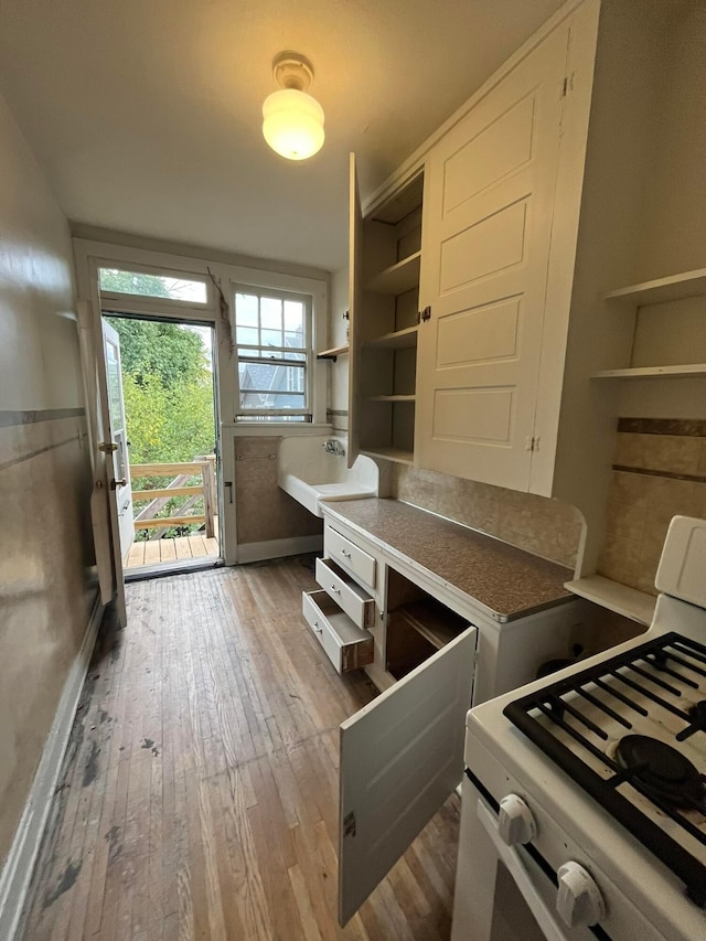 kitchen with white cabinetry, dark wood-type flooring, and white gas stove