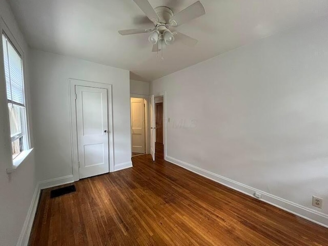 unfurnished bedroom featuring ceiling fan and dark hardwood / wood-style flooring