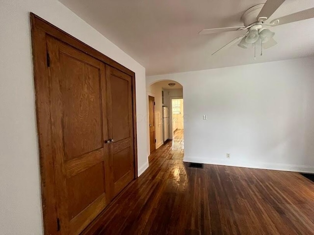 interior space with dark wood-type flooring and ceiling fan