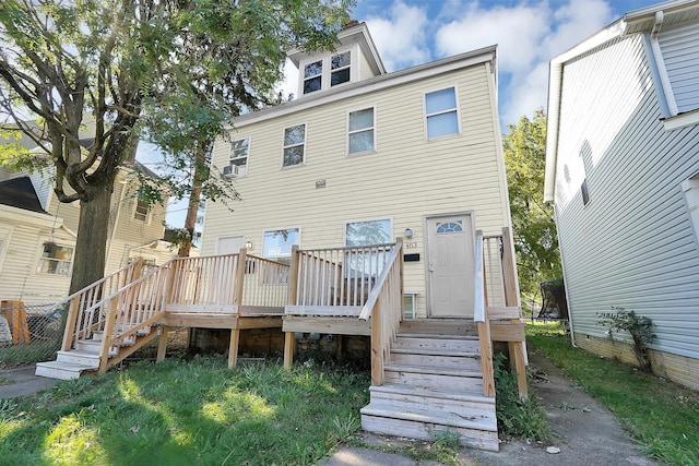 rear view of house featuring a wooden deck