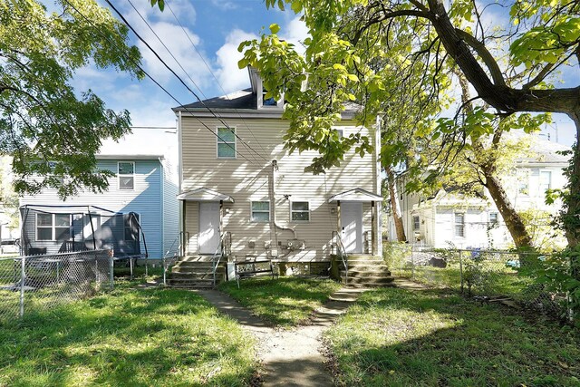 rear view of house featuring a yard