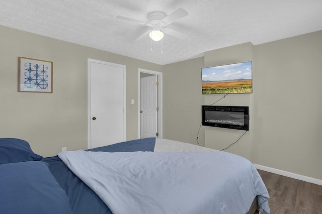 bedroom featuring dark hardwood / wood-style flooring, a textured ceiling, and ceiling fan