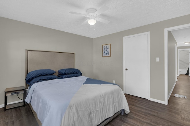 bedroom with dark hardwood / wood-style flooring, a textured ceiling, and ceiling fan