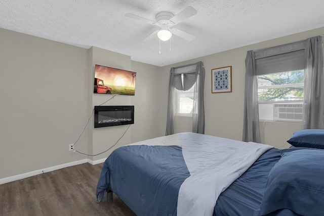 bedroom with cooling unit, a textured ceiling, dark hardwood / wood-style floors, and ceiling fan