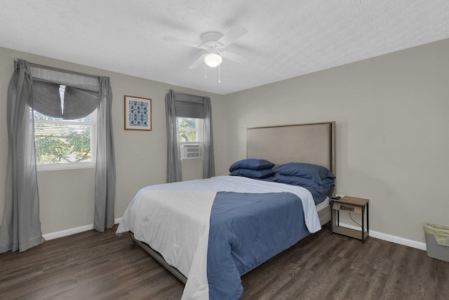 bedroom with dark wood-type flooring, ceiling fan, a textured ceiling, and cooling unit