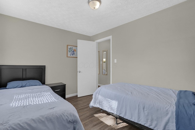 bedroom with dark wood-type flooring and a textured ceiling