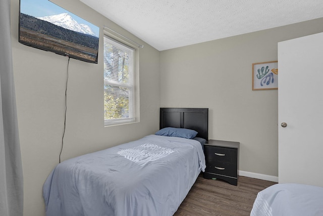 bedroom with dark hardwood / wood-style flooring and a textured ceiling