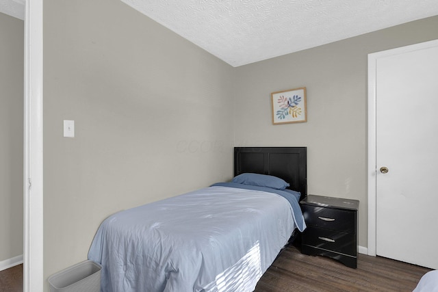 bedroom with dark wood-type flooring and a textured ceiling