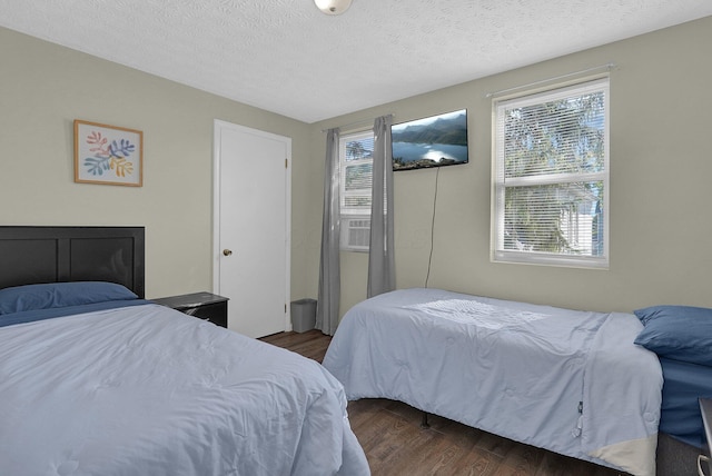 bedroom with dark hardwood / wood-style flooring and a textured ceiling