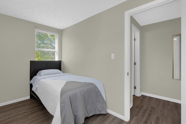 bedroom featuring dark hardwood / wood-style flooring and a textured ceiling