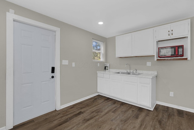 kitchen featuring white cabinetry, sink, and dark hardwood / wood-style floors