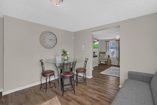 dining space with dark wood-type flooring and a textured ceiling