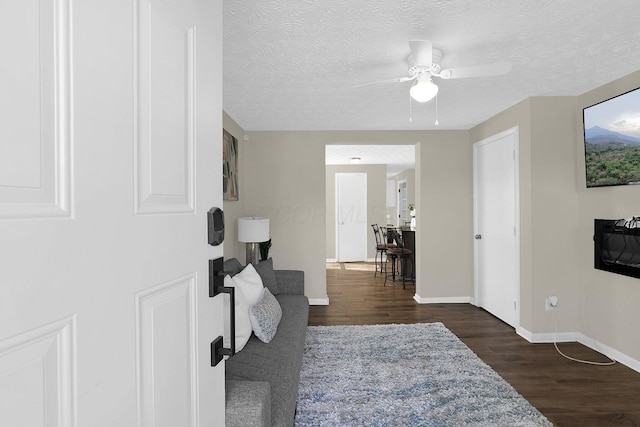 foyer entrance featuring dark wood-type flooring, ceiling fan, and a textured ceiling