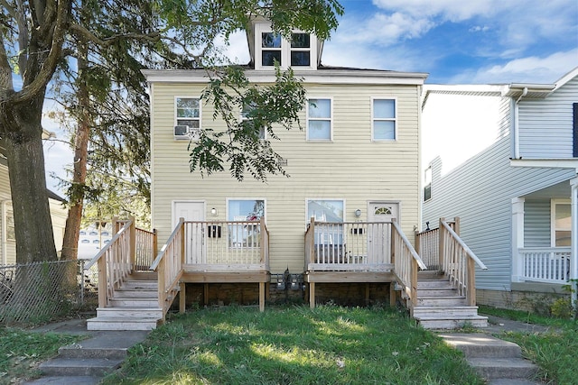 rear view of house featuring fence, a wooden deck, and stairway