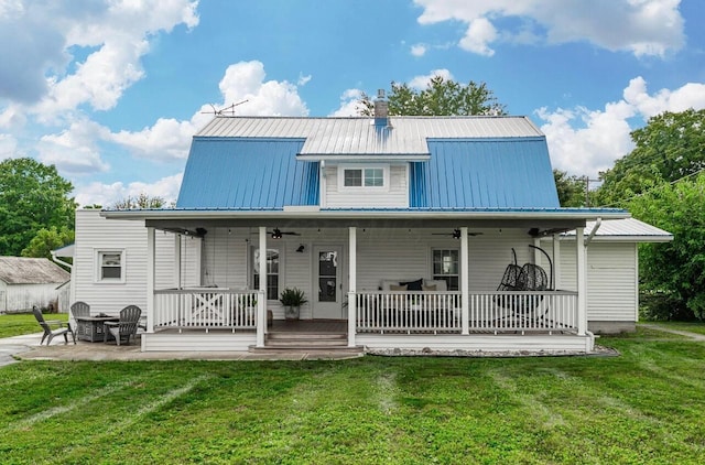 rear view of house with a porch, a patio area, ceiling fan, and a lawn