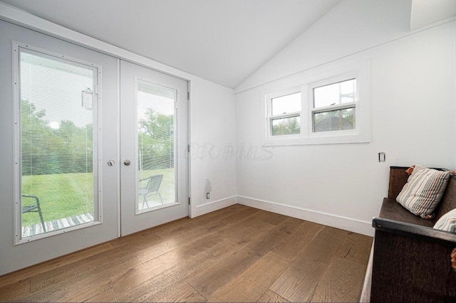 doorway featuring lofted ceiling, hardwood / wood-style floors, and french doors