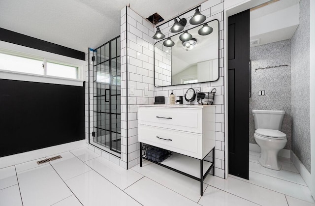 bathroom with tile walls, vanity, tile patterned flooring, and toilet