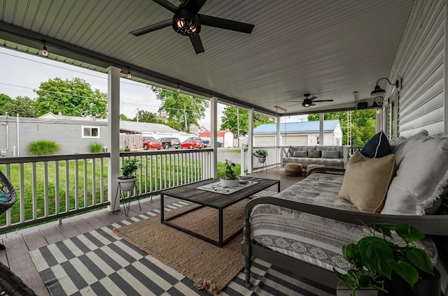 wooden deck with an outdoor living space, a yard, covered porch, and ceiling fan