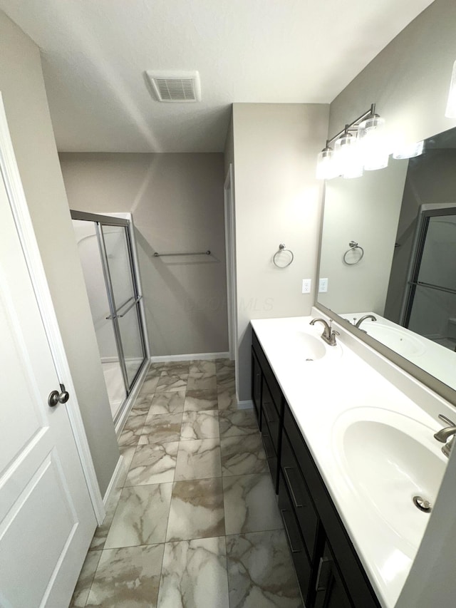 bathroom featuring visible vents, a shower stall, marble finish floor, and a sink
