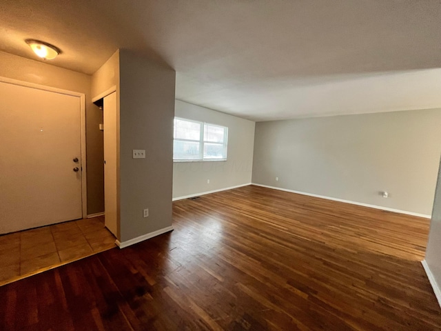 empty room with baseboards and wood finished floors