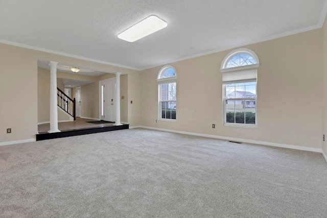 carpeted empty room with baseboards, stairway, visible vents, and crown molding