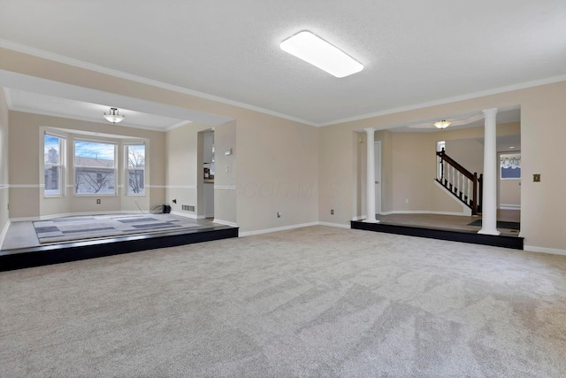 carpeted spare room featuring visible vents, baseboards, stairway, decorative columns, and crown molding