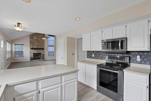 kitchen featuring lofted ceiling, stainless steel appliances, a wealth of natural light, and light countertops