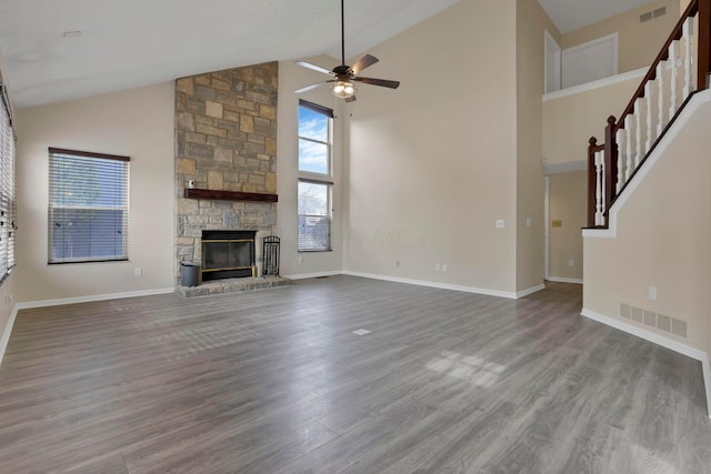 unfurnished living room with stairs, a fireplace, visible vents, and wood finished floors