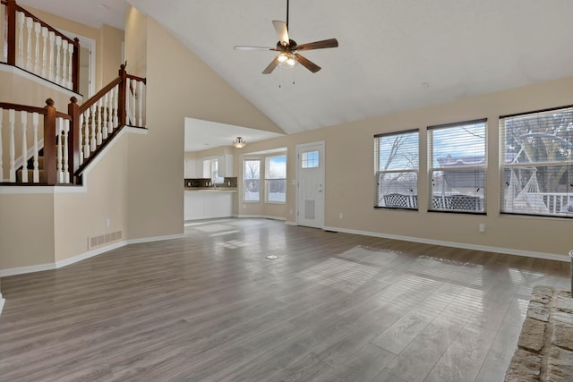 unfurnished living room with high vaulted ceiling, wood finished floors, visible vents, and a ceiling fan