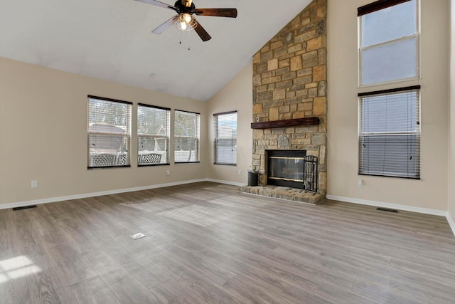 unfurnished living room featuring baseboards, a ceiling fan, wood finished floors, a fireplace, and high vaulted ceiling